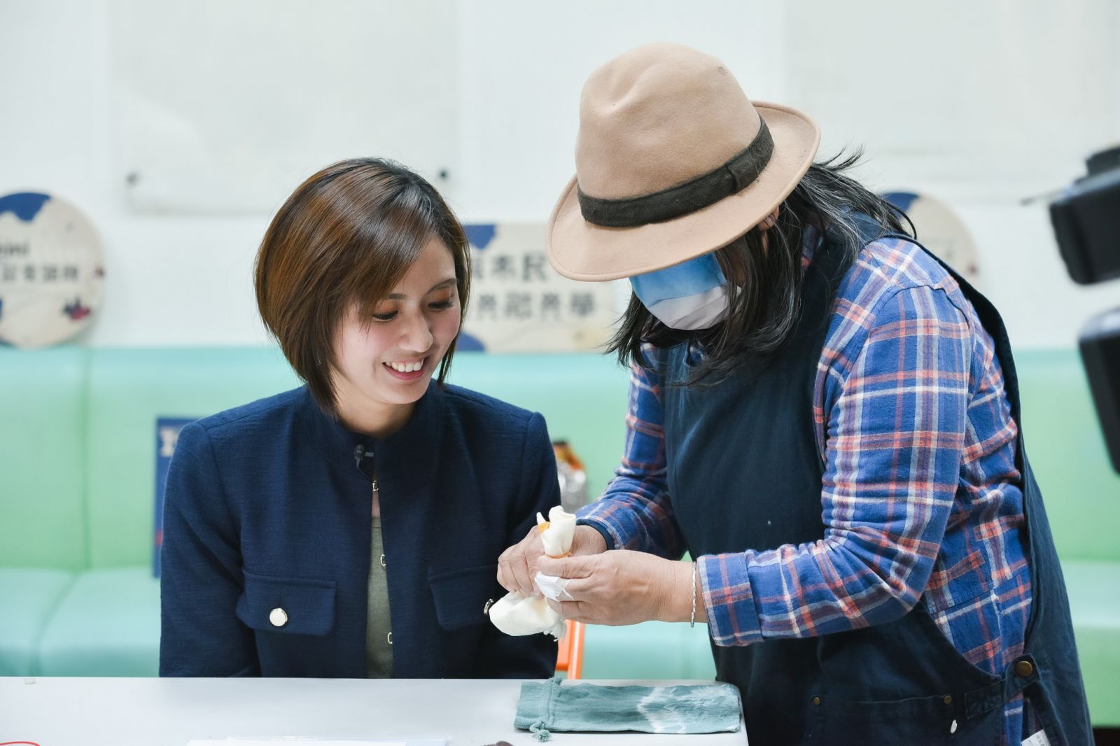 圖為本局局長參與林口場次成果展，周花燕老師指導DIY製作部落原生植物萃取顏料染束口袋。