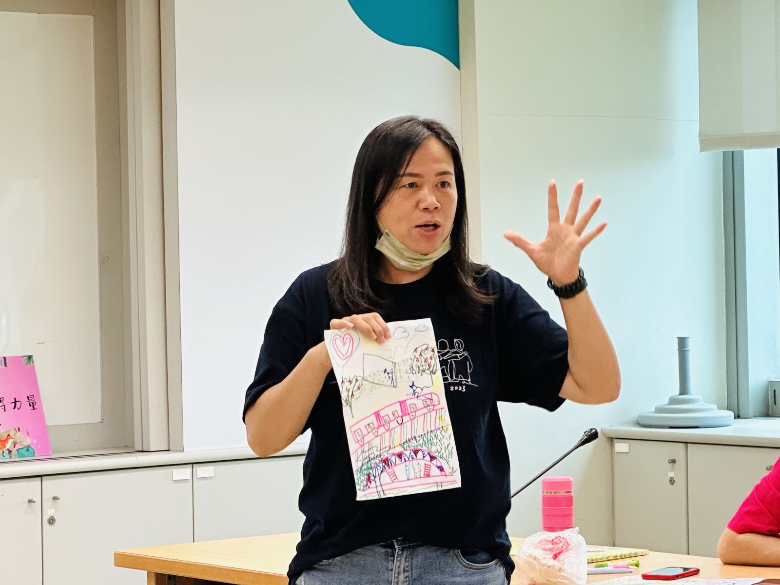 故事老師在課堂上以自己的畫作 說一則精彩的故事。(圖/新北市政府原民局提供)